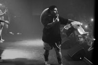 a black and white photo of a man on stage with a microphone