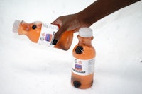 a person holding a bottle of orange juice